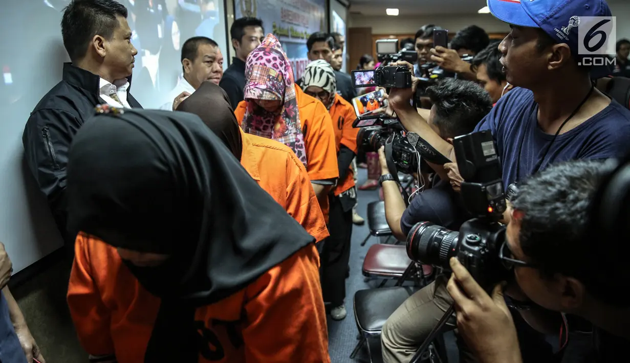 Awak media mengambil gambar para tersangka perdagangan orang ke Suriah dan Abu Dhabi dalam rilis di Bareskrim Mabes Polri, Kamis (10/8). Dalam kasus itu, polisi berhasil mengungkap dua jaringan yang ada di Jakarta dan Lombok. (Liputan6.com/Faizal Fanani)
