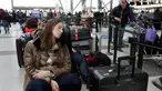 Penumpang maskapai Avianca menunggu penerbangan yang tertunda di Bandara Internasional John F Kennedy (JFK), New York, Senin (8/1). Banjir yang disebabkan kerusakan saluran air mengakibatkan kekacauan dan pembatalan sejumlah penerbangan. (AP/Richard Drew)