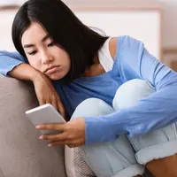 Ilustrasi perempuan dengan wajah kusam akibat paparan blue light dari smartphone ©Milkos