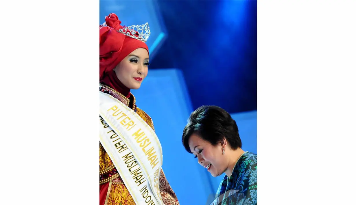 Ibu Harsiwi Achmad selaku Managing Director Indosiar mengenakan slendang kepada Annisa Darmawati (21) asal Jakarta yang dinobatkan sebagai Puteri Muslimah Indonesia 2014 (Liputan 6.com/Andrian M Tunay)