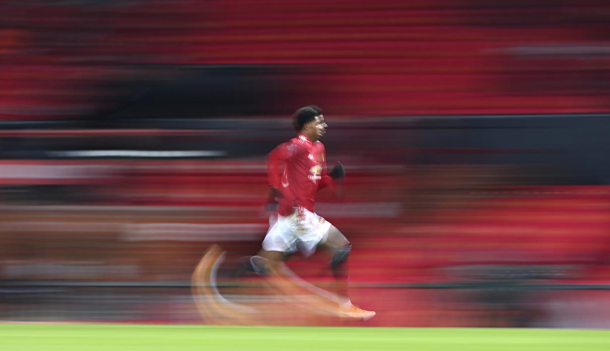 Pemain Manchester United, Marcus Rashford berlari mengejar bola pada laga babak keempat FA Cup 2020-21 melawan Liverpool di Old Trafford, Senin (25/01/2021). (Foto: AP/Pool/Laurence Griffiths)
