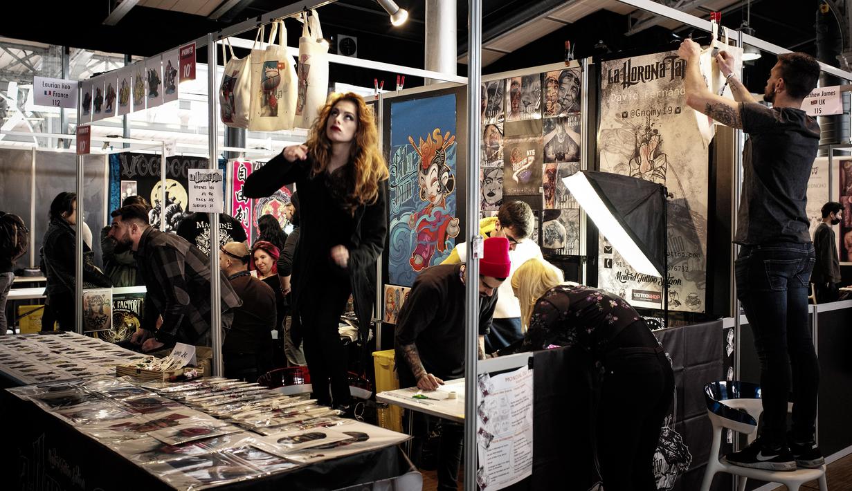 Peserta pameran mempersiapkan stan mereka selama Paris Tattoo Convention di Grand Halle de la Villette, Paris, Prancis, Jumat (9/3). Paris Tattoo Convention berlangsung dari tanggal 9 sampai 11 Maret. (Philippe LOPEZ/AFP)