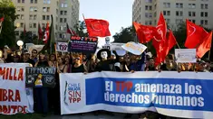 Sejumlah demonstran berunjuk rasa terhadap kesepakatan perdagangan Trans-Pacific Partnership (TPP) di depan gedung Pemerintah di Santiago, Chili, (4/2). Mereka membawa spanduk bertuliskan "The TPP mengancam hak asasi manusia". (REUTERS/Ivan Alvarado)