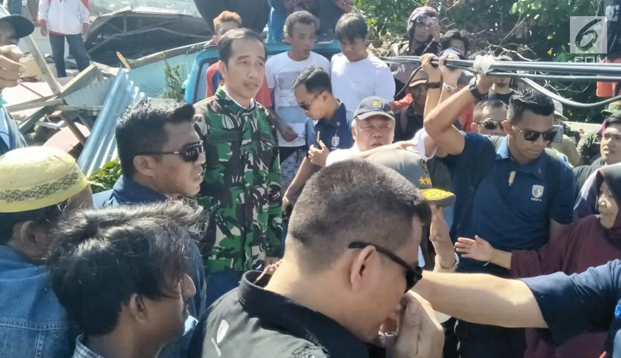 Presiden Joko Widodo (Jokowi) meninjau lokasi reruntuhan bangunan akibat gempa dan tsunami di Kota Palu, Sulawesi Tengah, Minggu (30/9). Jokowi tampak didampingi sejumlah menteri, termasuk Menteri PUPR, Basuki Hadimuljono. (Liputan6.com/Septian Deny)