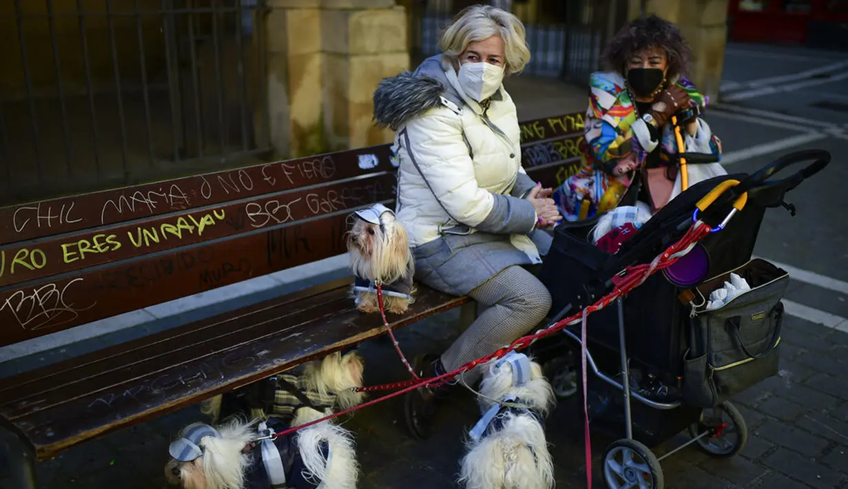 Seorang wanita menunggu dengan hewan peliharaannya untuk diberkati saat pesta Santo Antonius di Pamplona, Spanyol, 17 Januari 2022. Pesta santo pelindung hewan Spanyol ini dirayakan setiap tahun dan orang-orang membawa hewan peliharaan mereka ke gereja untuk diberkati. (AP Photo/Alvaro Barrientos)
