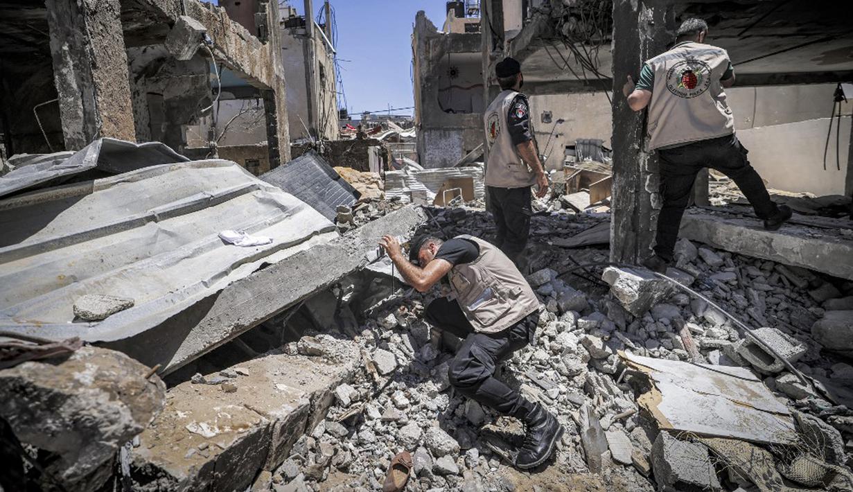 Pakar bahan peledak Hamas mencari proyektil yang tidak meledak dari reruntuhan bangunan setelah konflik Mei 2021 dengan Israel di Kota Gaza, Sabtu (5/6/2021). Perang 11 hari antara Hamas dan Israel menewaskan 254 orang Palestina dan 12 orang Israel. (MAHMUD HAMS/AFP)