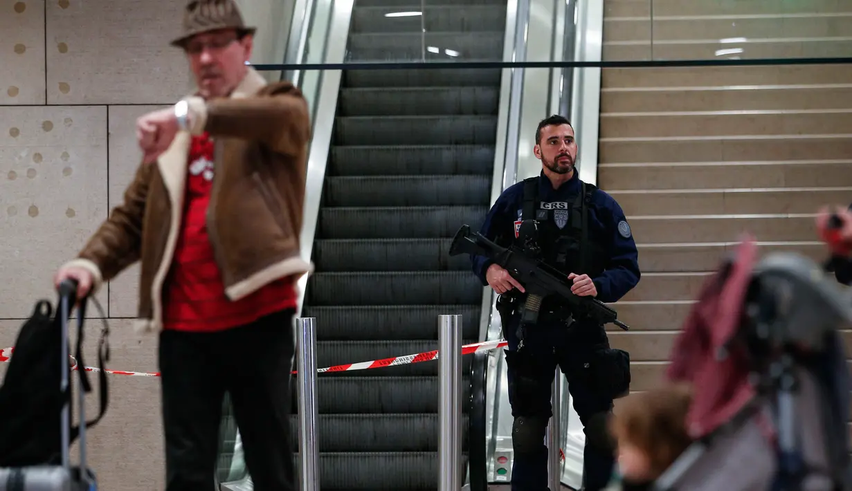 Petugas berjaga di sekitar lokasi insiden penembakan di Bandara Orly, Prancis, Sabtu (18/3). Tembakan dilepaskan polisi ke arah seorang pria yang berusaha merampas senjata milik tentara di Bandara Orly. (AP Photo)