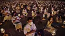 Umat Buddha mengenakan masker saat berdoa bersama di kuil Buddha Wat Dhammakaya, Bangkok (31/1/2020). Pemerintah Thailand mengumumkan 14 orang terkonfirmasi infeksi virus corona.Thailand memiliki jumlah kasus terbesar kedua di luar China. (AFP Photo/Lillian Suwanrumpha)