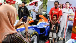 Pengunjung berfoto bersama di replika mobil Formula 1 yang ditunggangi pembalap Indonesia, Rio Haryanto pada acara Nonton Bareng F1 GP Australia 2016 Pertamina di Mall Bintaro Xchange, Tangerang Selatan, Minggu (20/3). (Liputan6.com/Fery Pradolo)