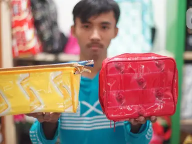 Pekerja memperlihatkan hasil dari sampah plastik yang diproduksi di kawasan Pasar Minggu, Jakarta, Senin (13/1/2020). Rumah daur ulang plastik itu memproduksi barang dari limbah plastik seperti tas, payung, dompet dan koper dengan harga jual Rp20ribu hingga Rp700ribu (Liputan6.com/Immanuel Antonius)