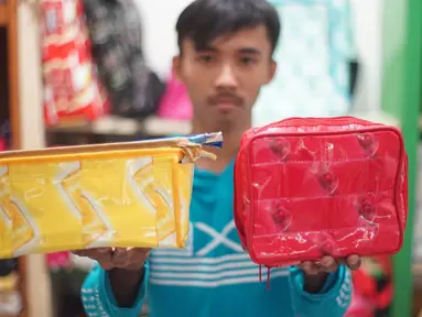 Pekerja memperlihatkan hasil dari sampah plastik yang diproduksi di kawasan Pasar Minggu, Jakarta, Senin (13/1/2020). Rumah daur ulang plastik itu memproduksi barang dari limbah plastik seperti tas, payung, dompet dan koper dengan harga jual Rp20ribu hingga Rp700ribu (Liputan6.com/Immanuel Antonius)