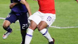 Gelandang Jepang, Takefusa Kubo (kiri) berusaha merebut bola yang dibawa pemain Chile, Jean Beausejour selama pertandingan grup C Copa America 2019 di Stadion Morumbi, Sao Paulo, Brasil (17/6/2019). Kubo resmi dikontrak selama enam tahun oleh Real Madrid. (AFP Photo/Nelson Almeida)