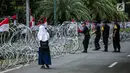 Personel Brimob memasang kawat berduri di sekitar area gedung KPU, Jakarta, Jumat (1/3). Kawat berduri itu untuk mengantisipasi massa Forum Umat Islam (FUI) dan Gerakan Jaga Indonesia yang akan menggelar aksi di depan KPU. (Liputan6.com/Faizal Fanani)