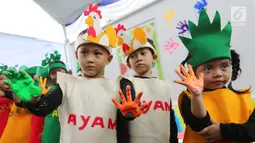 Anak-anak menunjukkan cap tangan yang dibaluri cat pada Festival Gizi Anak yang digelar Danone Nutricia, Bogor, Selasa (30/1). Kegiatan ini digelar dalam rangka Hari Raya Gizi Nasional yang jatuh pada tanggal 25 Januari 2018 lalu. (Liputan6.com)