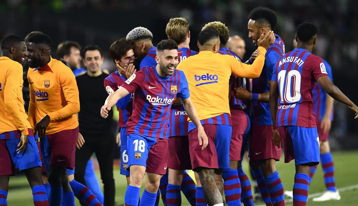 <p>Pemain Barcelona Jordi Alba (tengah) merayakan setelah mencetak gol ke gawang Real Betis pada pertandingan sepak bola La Liga Spanyol di Stadion Benito Villamarin, Seville, Spanyol, 7 Mei 2022. Barcelona menang 2-1. (AP Photo/Jose Breton)</p>