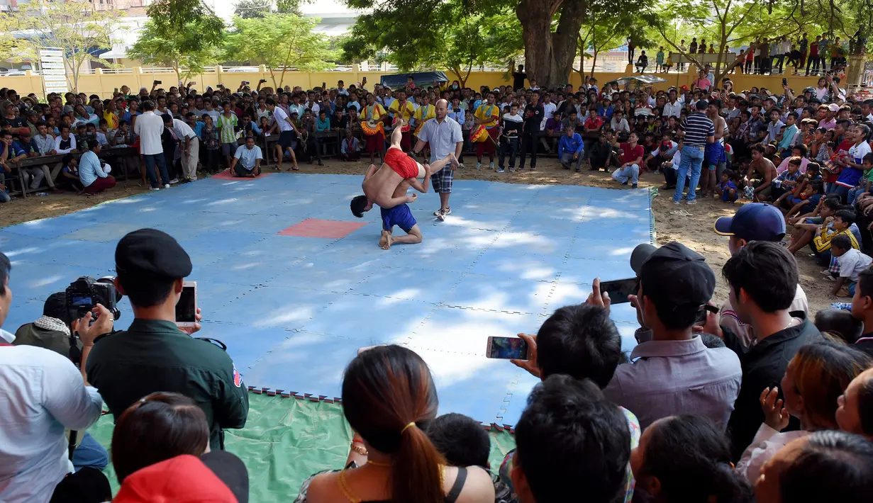 Suasana pertarungan gulat Khmer selama festival Pchum Ben atau festival kematian di desa Vihear Suor, provinsi Kandal (9/10). Festival ini menandai berakhirnya festival 15 hari bagi orang mati. (AFP Photo/Tang Chhin Sothy)
