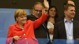 Dari atas tribun kehormatan, Kanselir Jerman, Angela Merkel menyapa tim Der Panzer yang berlaga melawan Portugal di penyisihan Piala Dunia Grup G di Fonte Nova Arena, Brasil, (16/6/2014). (AFP PHOTO/Fabrice Coffrini)