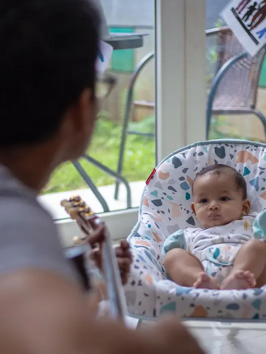 <p>Fedi Nuril bermain gitar saat menidurkan anaknya Aksa. Dikenal sebagai sosok yang family man banget, tentunya Fedi Nuril sangat telaten dalam asuh buah hati. (Instagram/fedinuril)</p>