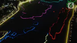 Foto udara memperlihatkan warna warni lampu Danau Archipelago di Taman Mini Indonesia Indah (TMII), Jakarta, Sabtu (31/12/2022). TMII menjadi salah satu lokasi acara puncak perayaan pergantian tahun di DKI Jakarta. (Liputan6.com/Herman Zakharia)