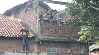 Warga Garut sampai memanjat pohon dan menaiki atap rumah demi menyaksikan aksi beberapa pemain Persib Bandung saat melawan Garut Selection di Stadion Jayaraga, Minggu (7/2/2016). (Bola.com/Permana Kusumadijaya)