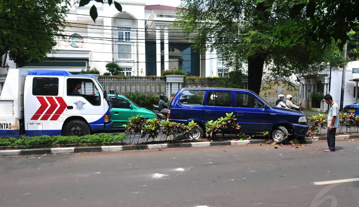 Pengemudi tampak melihat kondisi mobilnya usai menabrak pembatas jalan. (Liputan6.com/Johan Tallo)