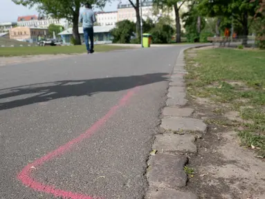 Gambar pada 8 Mei 2019 menunjukkan garis berwarna pink yang diperuntukkan bagi bandar narkotika di aspal Taman Goerlitzer, Berlin. Nantinya, para bandar hanya boleh bertransaksi di dalam zona berupa coretan kotak dengan cat semprot berwarna pink itu saja. (Paul Zinken / dpa / AFP)