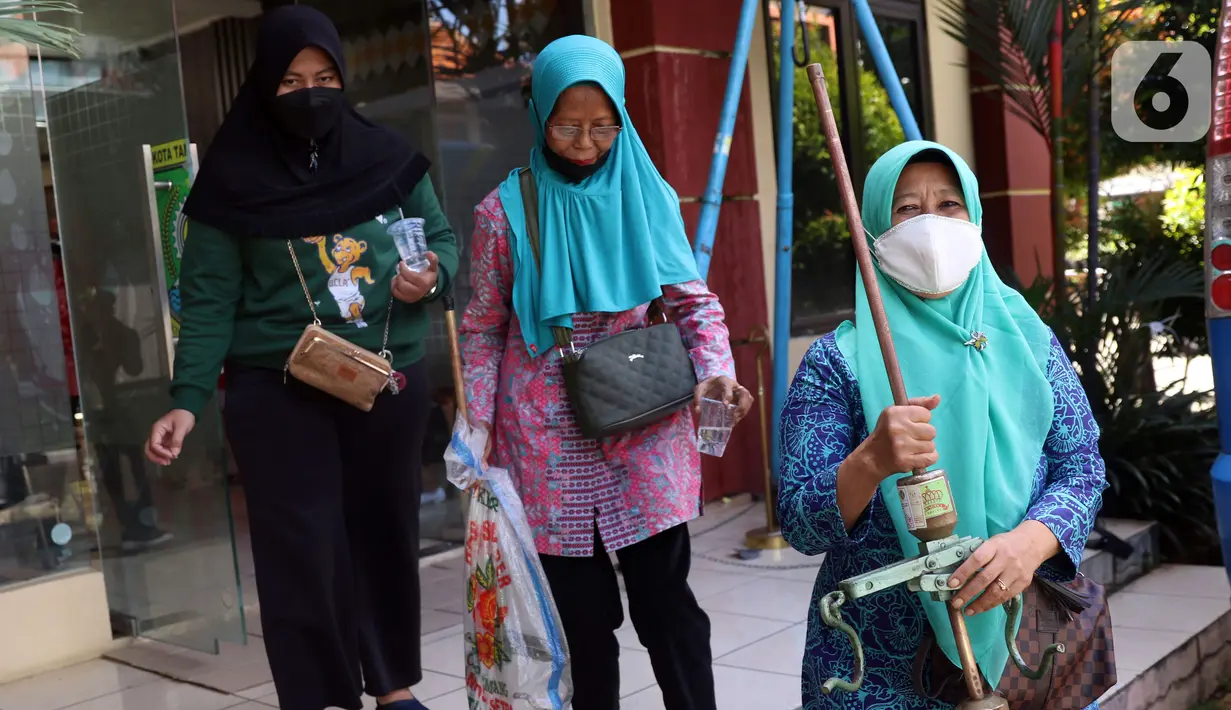Petugas UPT Disperindagkop UKM Kota Tangerang membawa alat ukur timbangan saat sidak di Kecamatan Larangan, Kota Tangerang, Banten, Kamis (2/12/2021). Pengecekan dilakukan untuk memastikan alat ukur tersebut tidak ada kesalahan. (Liputan6.com/Angga Yuniar)