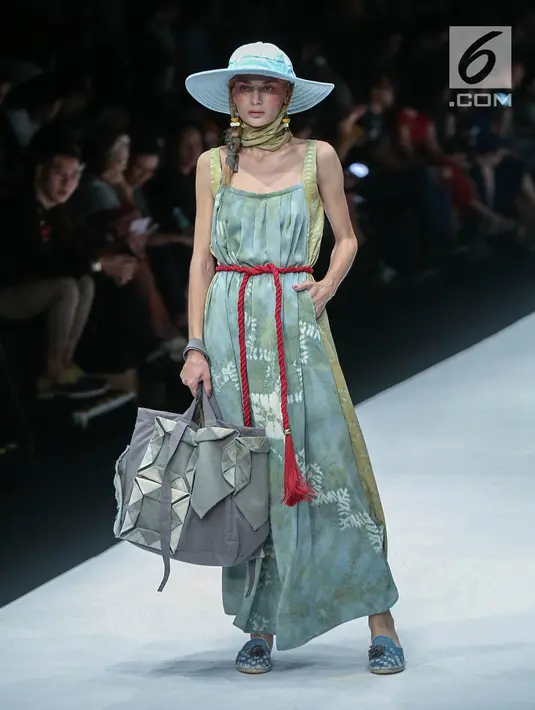 Model memperagakan busana rancangan HUMBANG SHIBORI x PURANA saat Jakarta Fashion Week 2019 di Senayan City, Jakarta, Kamis (25/10). Tenun ikat Humbang Shibori merupakan kerajinan kriya yang dibuat dengan metode ikat celup. (Liputan6.com/Faizal Fanani)