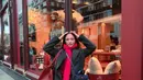 Ia padukan long sleeve dan syal wol merah dengan long coat abu-abu dan rok hitam [@amelcarla]