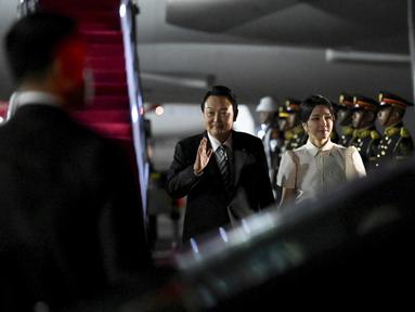 Presiden Korea Selatan Yoon Suk Yeol dan istrinya Kim Keon-hee tiba di Bandara Internasional Ngurah Rai di Bali, Minggu, 13 November 2022. Presiden Yoon Suk Yeol yang ditemani istri cantiknya Kim Keon-hee berencana menghadiri pertemuan puncak KTT G20 di Nusa Dua di Bali. (Sonny Tumbelaka/Pool Photo via AP)