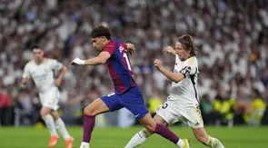 Joao Felix dari Barcelona, kiri, dilanggar oleh pemain Real Madrid Luka Modric saat pertandingan sepak bola La Liga Spanyol antara Real Madrid dan Barcelona di stadion Santiago Bernabeu di Madrid, Spanyol, Minggu, 21 April 2024. (AP Photo/Manu Fernandez)