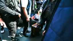 Petugas kepolisian memasukkan barang bukti hasil penggeledahan dari rumah di Sentul terkait dugaan kasus korupsi ke dalam gedung Direktorat Reserse Kriminal Khusus (Disreskrimsus) Polda Metro Jaya, Kamis (9/7/2026), (KLY/Budy Santoso)