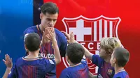 Gelandang baru Barcelona, Philippe Coutinho menyapa anak-anak saat perkenalan dirinya di Nou Camp, Barcelona (8/1). Coutinho diboyong Barcelona dengan harga sebesar 400 juta euro (sekitar Rp 6,45 triliun). (AFP Photo/Lluis Gene)