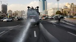 Kendaraan Water Canon kepolisian menyempotkan desinfektan untuk mensterilkan jalan-jalan di Teheran, Iran pada 1 Maret 2020. Sejauh ini, Iran mencatat ada 1.501 kasus virus Corona dengan 66 korban meninggal. (AP Photo/Vahid Salemi)