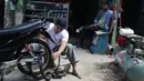 Vokalis band Repvblik, Ruri menjadi tukang tambal ban saat syuting pembuatan video klip 'Sayang Sampai Mati' di kawasan Depok, Jawa Barat, Kamis (19/1). (Liputan6.com/Herman Zakharia)