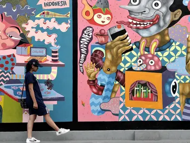 Pengunjung melintas di depan mural karya seniman Yogyakarta yang bertajuk INDONESIA IS GREAT  di museum Galeri Nasional, Jakarta, Sabtu (22/7). Pameran Mural tersebut merupakan agenda rutin museum Galeri Nasional. (Liputan6.com/Helmi Afandi)