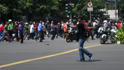Di tengah kepanikan pasca ledakan di Jalan Thamrin, Jakarta, seorang pria yang diperkirakan berusia antara 20-30 tahun, berpakaian kaos dan bertopi hitam serta membawa ransel merah, tiba-tiba mengeluarkan senjata, Kamis (14/1). (REUTERS/Veri Sanovri/Xin)