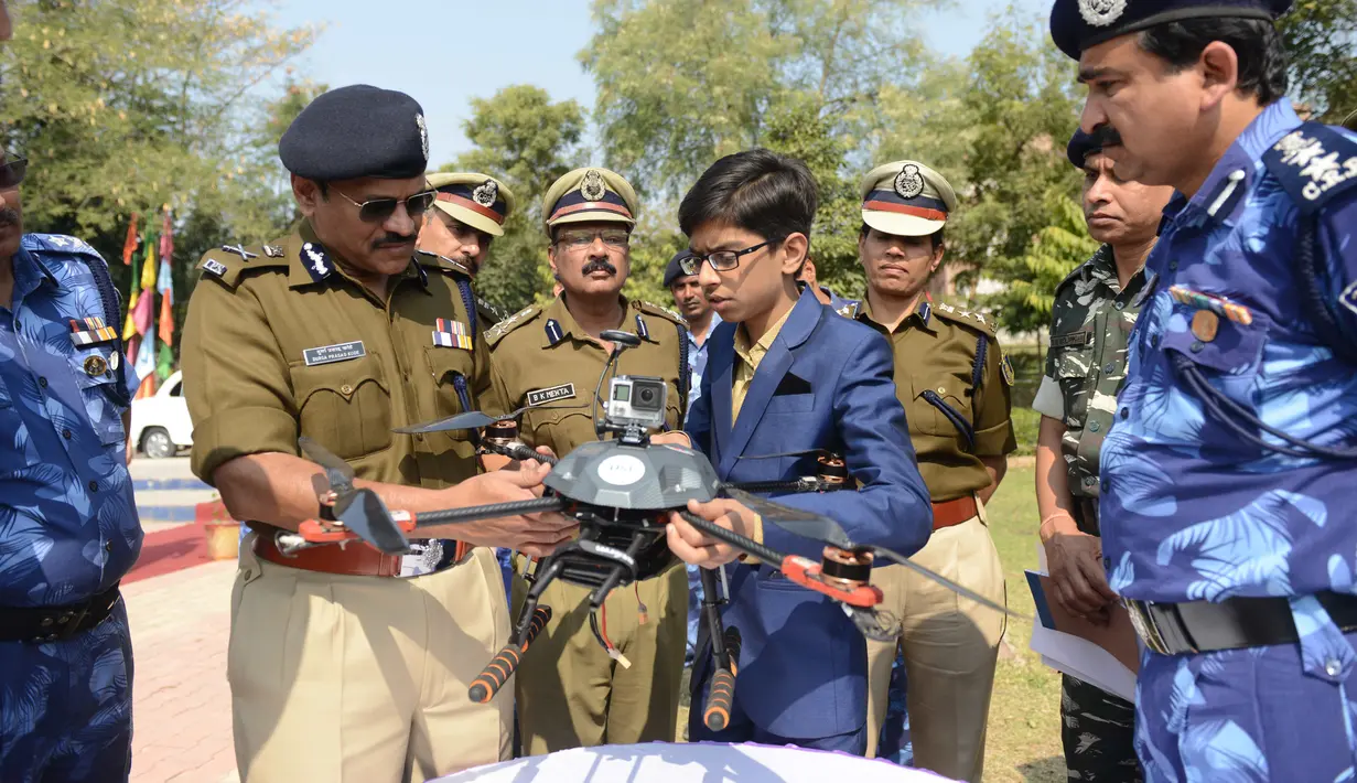 Harshwardhan Zala (14) menjelaskan drone buatannya kepada Pasukan Kepolisian Cadangan Pusat (CRPF) di kamp Rapid Action Force, Ahmedabad, India, 15 Januari 2017. Drone ciptaan Harshwardhan ini kini digunakan oleh aparat keamanan India. (Sam Panthaky/AFP)