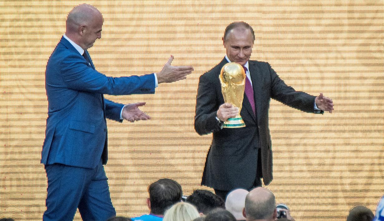 Presiden Rusia Vladimir Putin memegang trofi Piala Dunia dalam pembukaan upacara  "FIFA World Cup Trophy Tour" di stadion Luzhniki di Moskow (9/9). Piala Dunia 2018 adalah Piala Dunia FIFA ke-21. (AFP Photo/Mladen Antonov) 