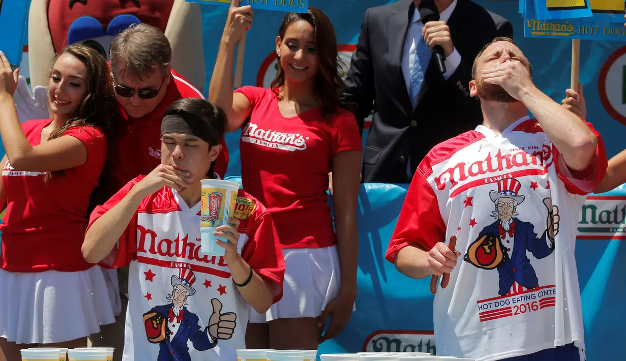 Peserta bernama Matt Stonie (kiri) dan Joey Chestnut saat beradu makan Hot Dog di Nathan's Famous 4 Fourth of July International Hot Dog-Eating Contest, Brooklyn , New York , AS, (4/7).( REUTERS / Andrew Kelly)