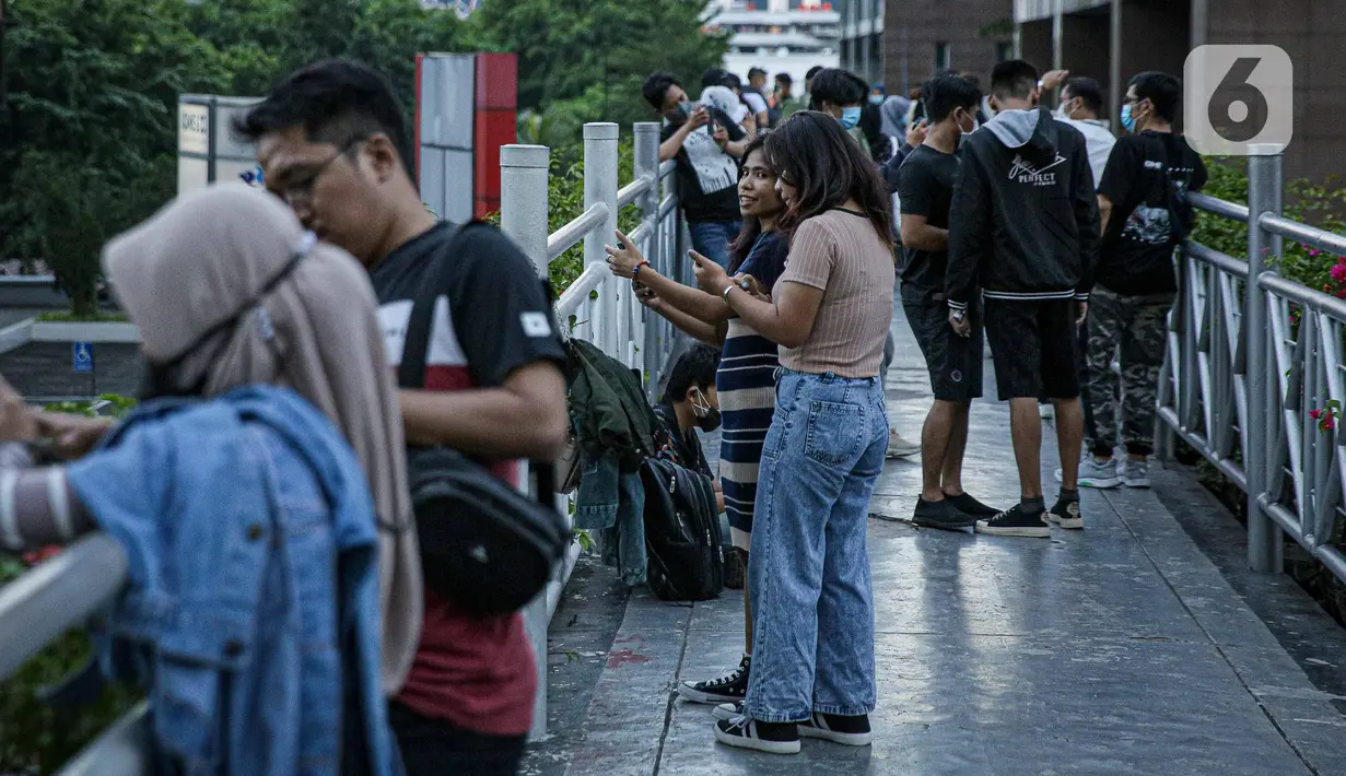Warga berkumpul diatas JPO tanpa atap di Jakarta, Minggu (12/9/2021). Kasus baru positif Covid-19 di Indonesia per Minggu (12/9) bertambah sebanyak 3.779 kasus Jumlah tersebut membuat total kasus virus corona sejak awal pandemi mencapai 4.167.511 kasus. (Liputan6.com/Faizal Fanani)