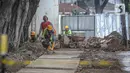 Pekerja membongkar jalur pedestrian di kawasan Kota Tua, Jakarta, Rabu (23/3/2022). Pemprov DKI Jakarta merevitalisasi pedestrian Kota Tua menjadi plaza pedestrian untuk mendukung program zona rendah emisi di destinasi wisata sejarah tersebut. (Liputan6.com/Faizal Fanani)