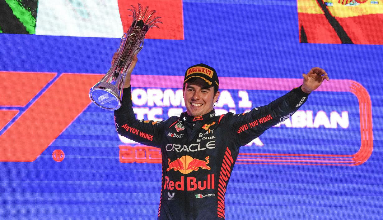 Pebalap Red Bull, Sergio Perez merayakan kemenangan setelah finis pertama saat Formula 1 GP Arab Saudi 2023 yang berlangsung di Jeddah Corniche Circuit, Senin (20/03/2023) WIB. Kemenangan tersebut menjadi yang kelima di ajang balap Formula 1 bagi pebalap asal Meksiko tersebut. (AP Photo/Hassan Ammar)