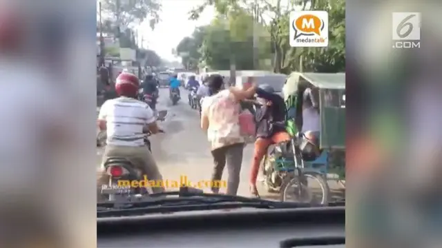 Seorang emak-emak asal Medan memukul tukang becak dengan helmnya, saat ia menyalip dan motornya terjepit becak.