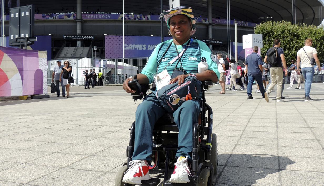 Seorang volunteer disabilitas, Ndieme Lame berpose di depan Stade de France saat Olimpiade Paris 2024 pada 7 Agustus 2024. (AP Photo/Tom Nouvian)