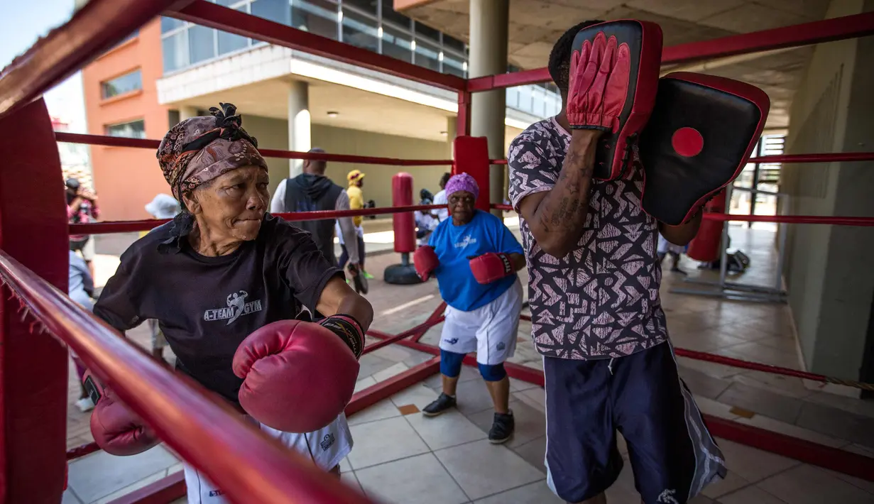 Gladys Ngwenya (kiri) dan Constance Ngubane (tengah) 79 tahun mengikuti latihan "Boxing Gogos" yang diselenggarakan oleh "A Team Gym" di Cosmo City di Johannesburg (19/9). Peserta "Boxing Gogos" berusia lebih dari 70 tahun. (AFP Photo/Gulshan Khan)