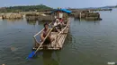 Warga menggunakan perahu  menyaksikan puing-puing bangunan  rumah yang kembali muncul di kawasan Bendungan Karian yang mengering di Kampung Somang, Lebak, Banten, Jumat, 7 Agustus 2026. (KLY/ Arie Basuki)