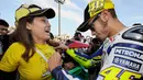 Pebalap MotoGP, Valentino Rossi, memberikan tanda tangan kepada fans wanita saat GP Jepang di Sirkuit Motegi, Jepang, Jumat (1/10/2010). (AFP/Toru Yamanaka)