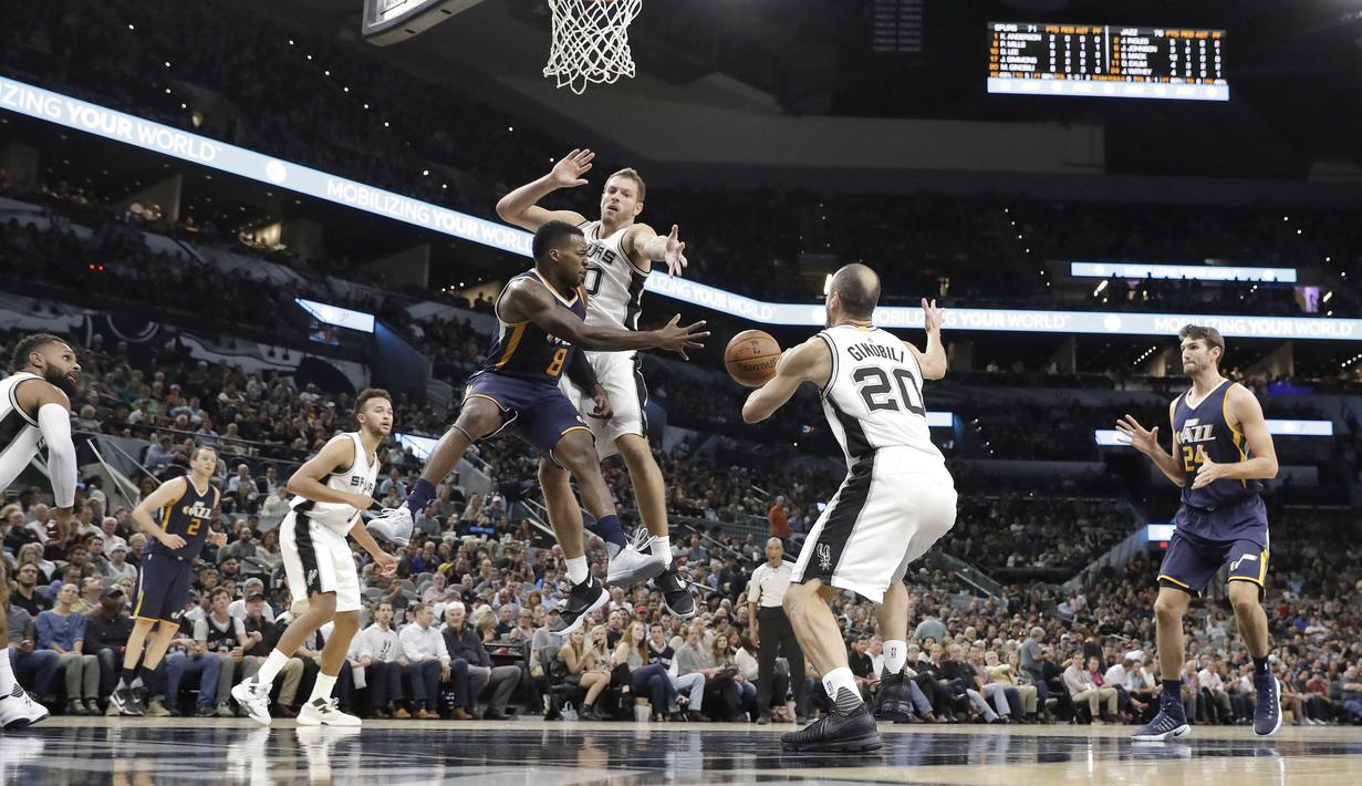 Aksi pemain Utah Jazz, Shelvin Mack #8 melepaskan umpan dari hadangan pemain San Antonio Spurs, David Lee #10  pada laga NBA basketball game di AT&T Center, San Antonio, (1/10/2016). Utah menang 106-91. (AP/Eric Gay)