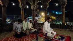 Jemaah pria muslim India menjalankan salat tarawih selama bulan suci Ramadan di Masjid Jama di New Delhi, India (23/5). Seperti jutaan muslim di seluruh dunia, muslim India juga menjalankan salat Terawih pada malam bulan Ramadan. (AFP/Chandan Khanna)